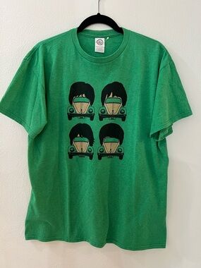 Vintage green Beatles VW cars that are topped with Beatles wigs haircuts designs